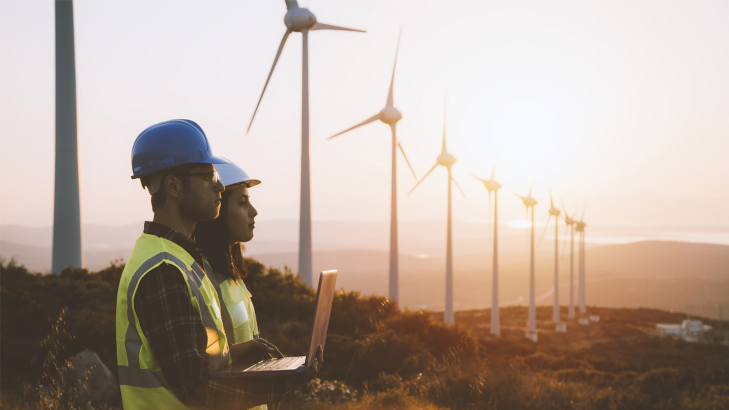 two workers on laptop in field