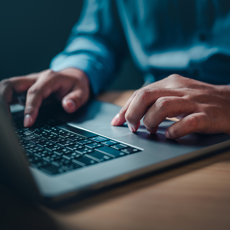 person using laptop in semi dark room