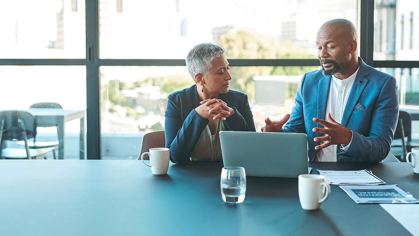 two people in a meeting with a laptop
