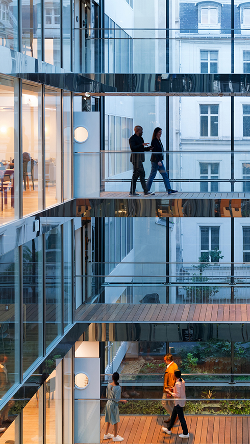 modern building in Paris, the walls are made of glass, at the end of the day, taken slightly against the light, wide view