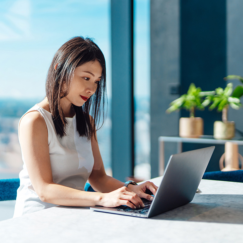 woman using laptop near window