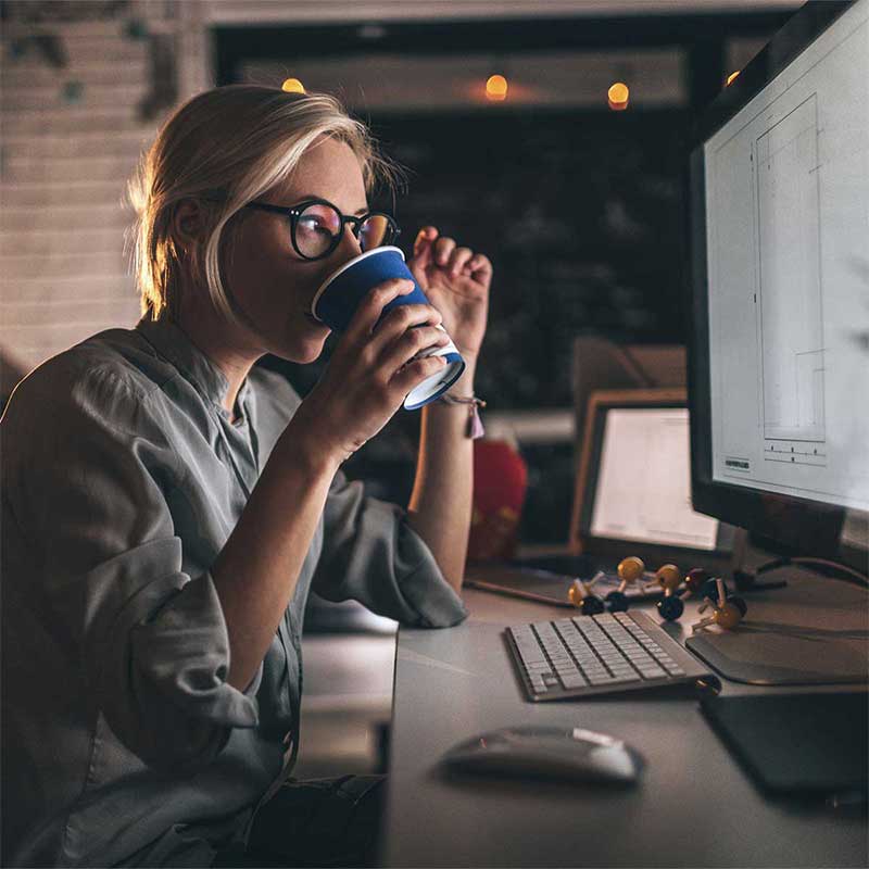 woman drinking coffee while using computer 