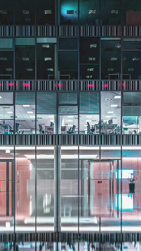 Office windows at night. Corporate building. Concept for employment, business, corporate, working. Exterior of modern office building. Architecture abstract background.