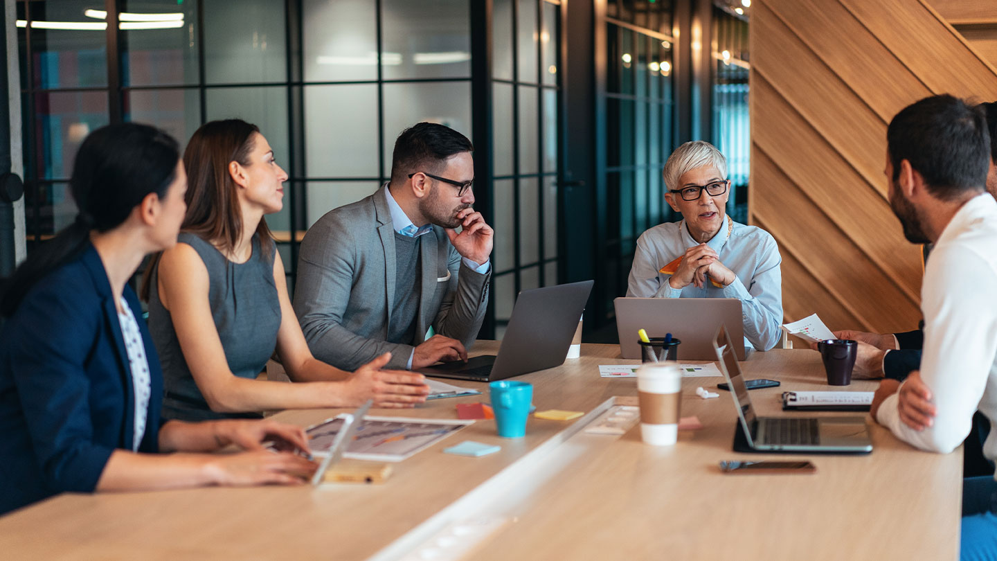 5 people in a meeting room banner