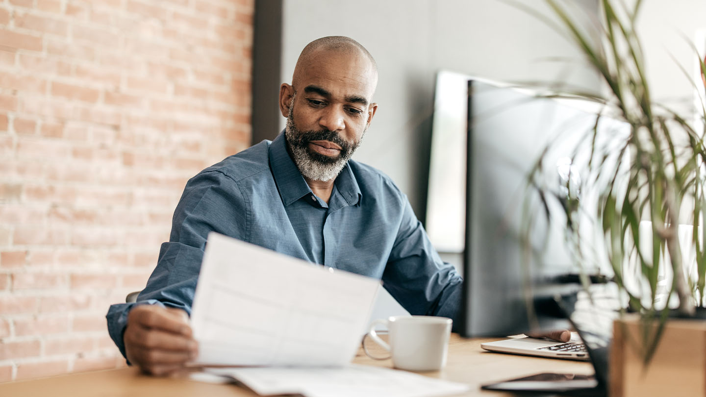 Person reading documents at his desk