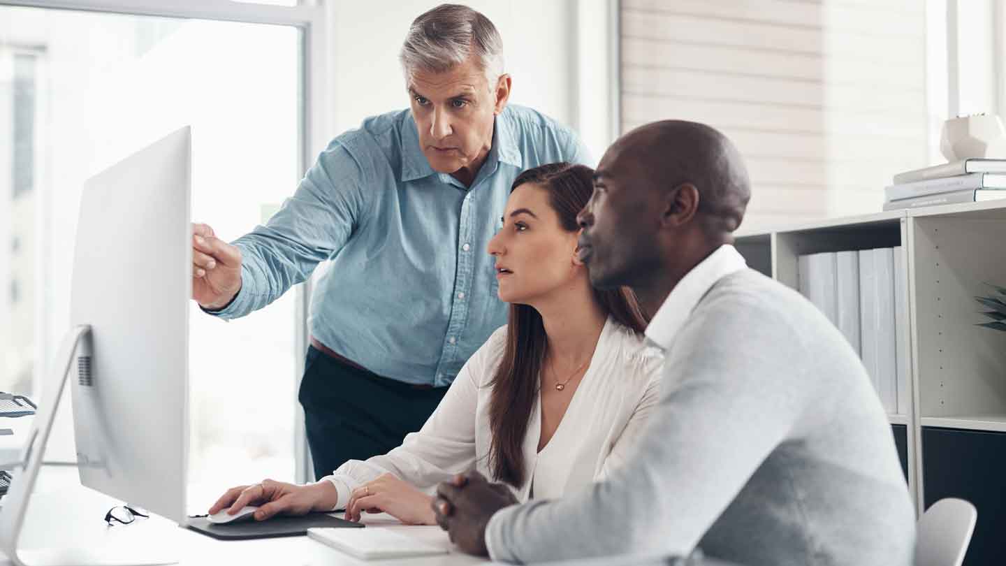 3 people using a desktop computer