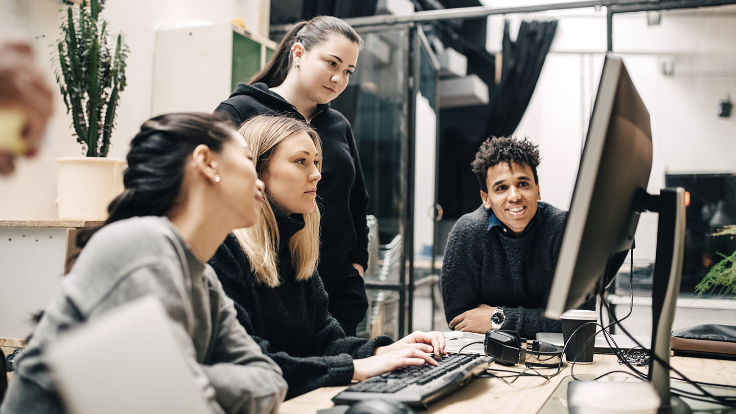 4 people using a computer banner