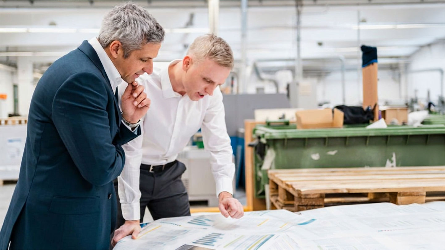 2 men looking at data prints