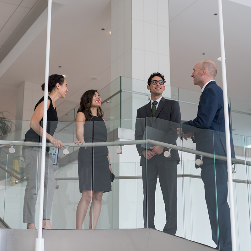 4 people on an office balcony speaking